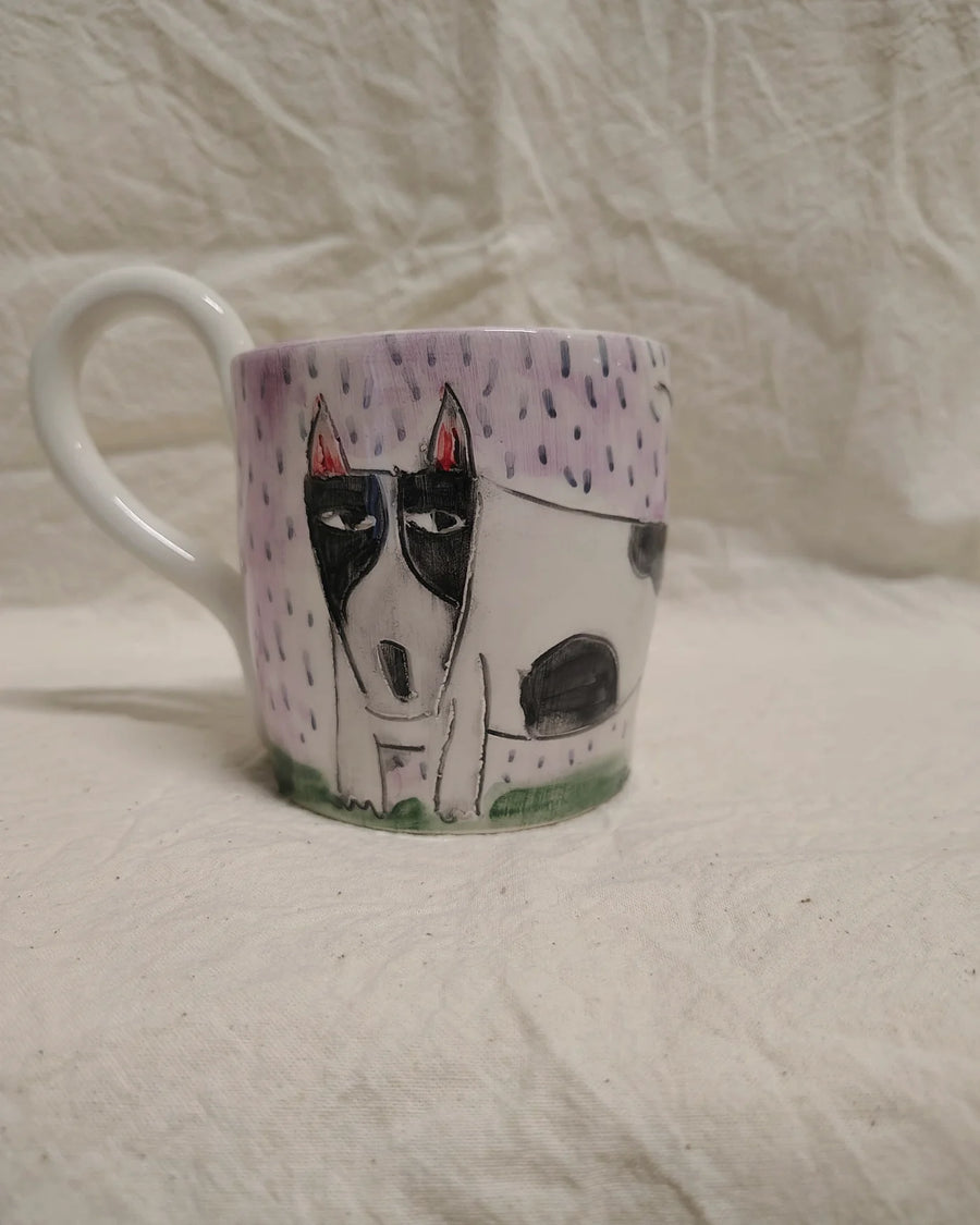 Tazza decorata con un cane e la pioggia, su fondo lilla