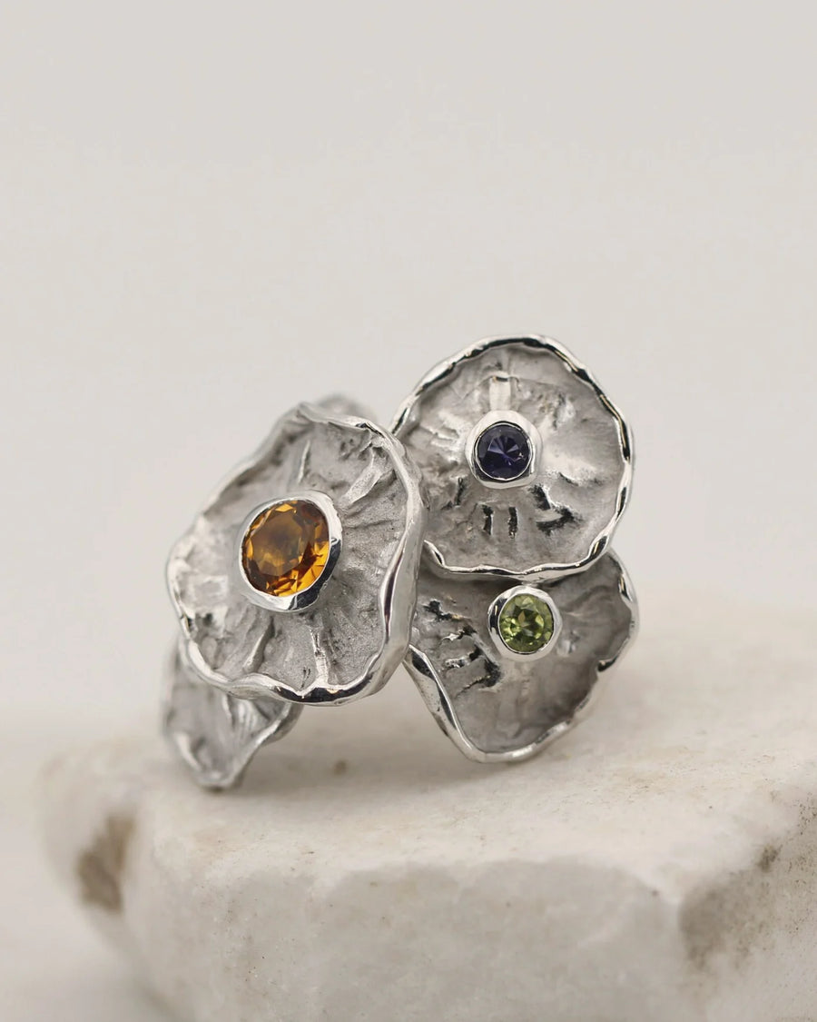 Anello Winter Flower in argento con cinque fiori e pietre semipreziose, su una pietra bianca