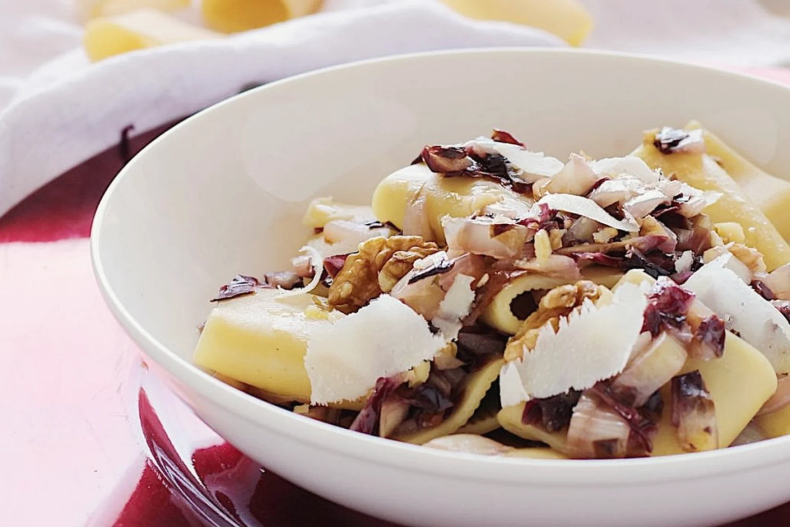 Un piatto di pasta con radicchio e scaglie di formaggio