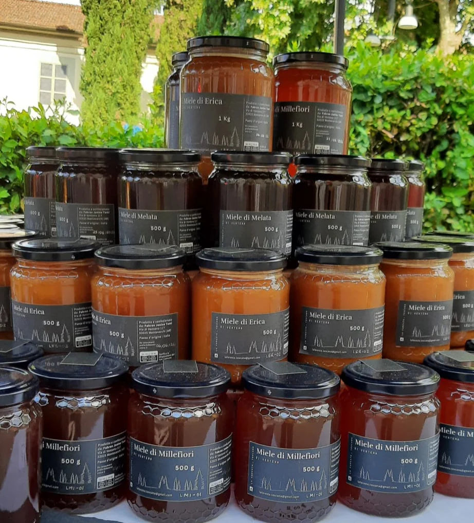 Vasetti di conserve allineati su un banco, con il giardino sullo sfondo