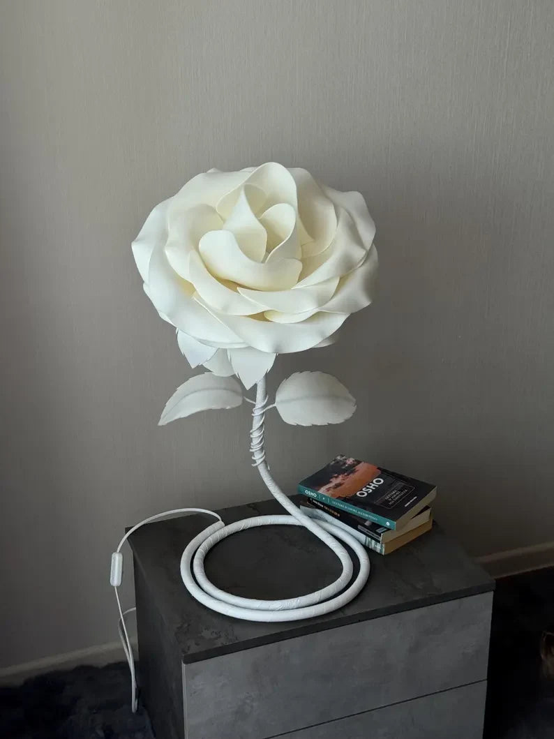 Lampada a forma di rosa bianca spenta su un comodino scuro