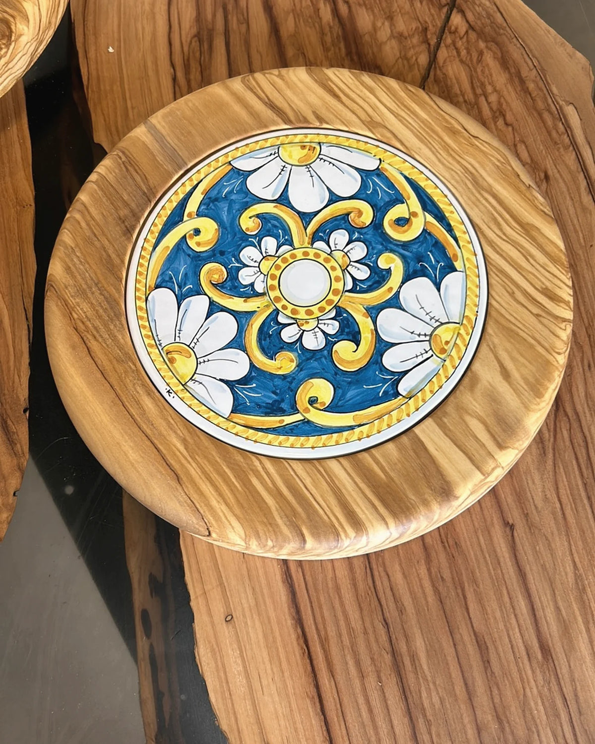 Mattonella in maiolica incastonata in un tagliere di legno d'ulivo