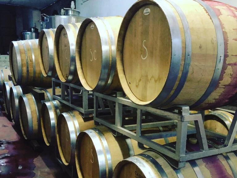 Botti di rovere allineate su cavalletti nel tinaio